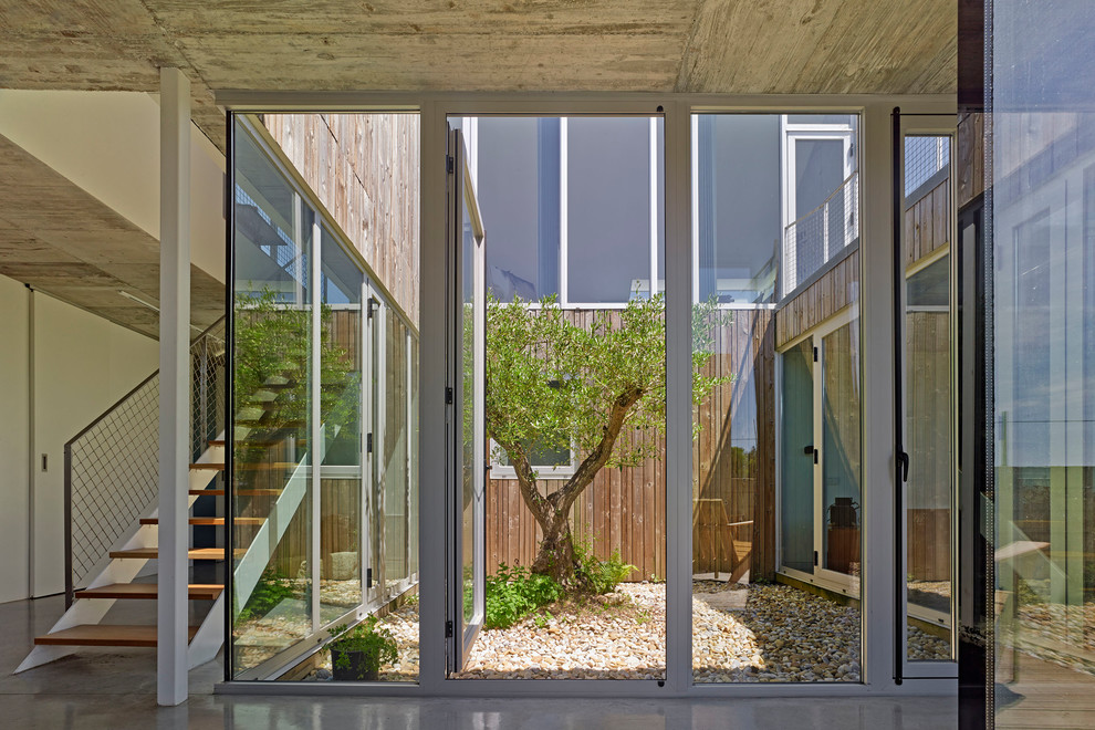 This is an example of a small contemporary courtyard patio in Other with no cover and gravel.
