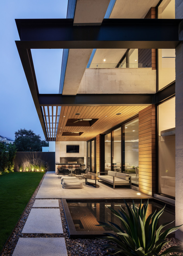 Стильный дизайн: двор среднего размера на заднем дворе в современном стиле с летней кухней, покрытием из бетонных плит и навесом - последний тренд