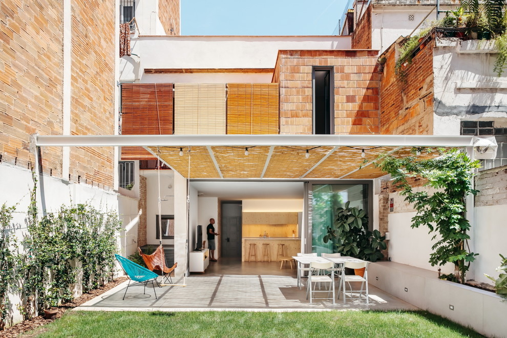 Foto de patio contemporáneo en patio trasero con losas de hormigón y pérgola