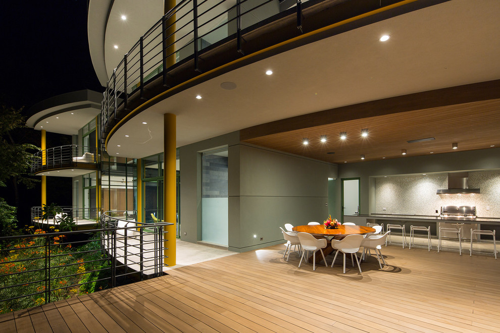 Cette image montre une terrasse arrière minimaliste avec une cuisine d'été et une extension de toiture.