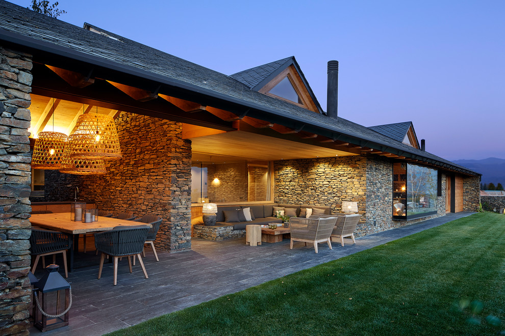 Idées déco pour une terrasse arrière campagne avec une cuisine d'été, des pavés en pierre naturelle et une extension de toiture.