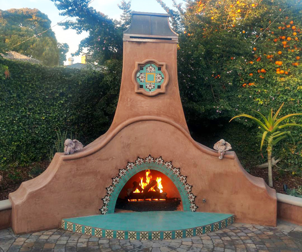 Großer Mediterraner Patio hinter dem Haus mit Feuerstelle und Betonboden in Los Angeles