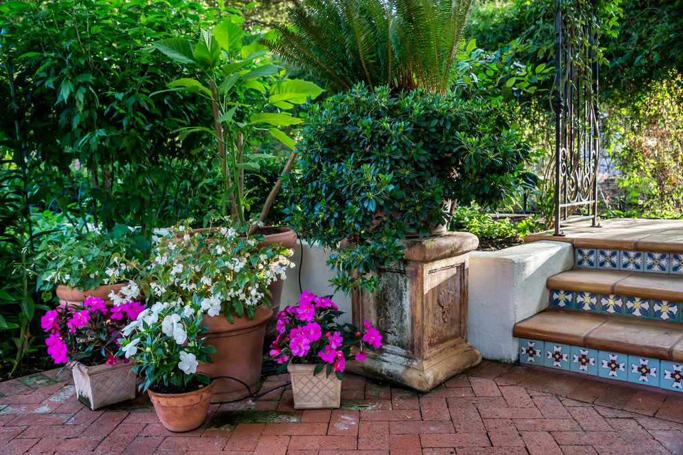 На фото: большой двор на заднем дворе в средиземноморском стиле с мощением клинкерной брусчаткой