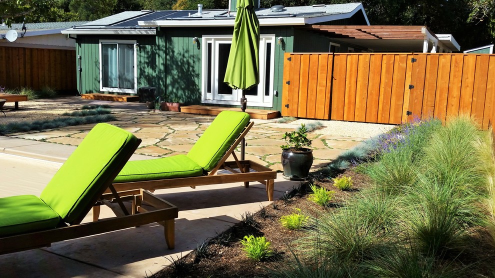 Foto di un piccolo patio o portico minimalista dietro casa con un focolare, ghiaia e nessuna copertura