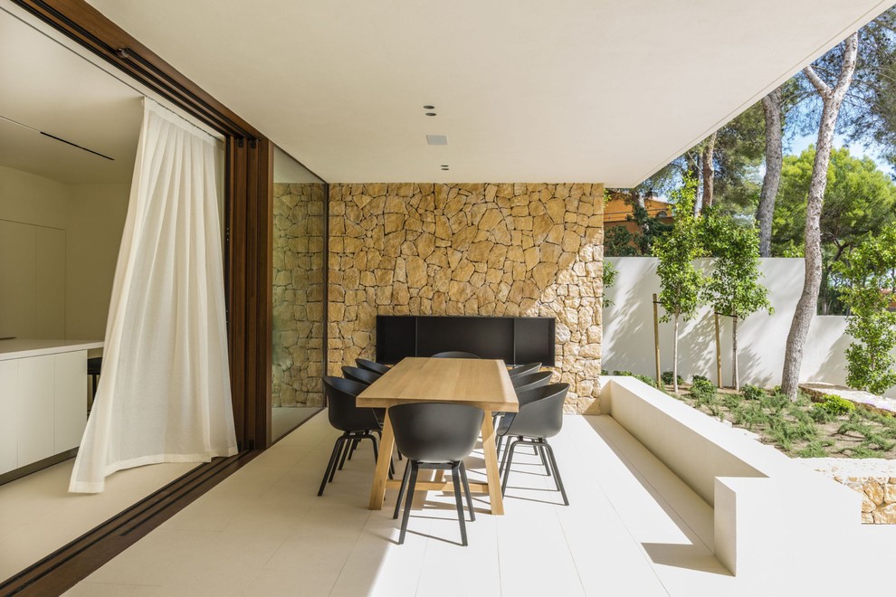 Идея дизайна: двор в средиземноморском стиле с уличным камином, покрытием из плитки и навесом