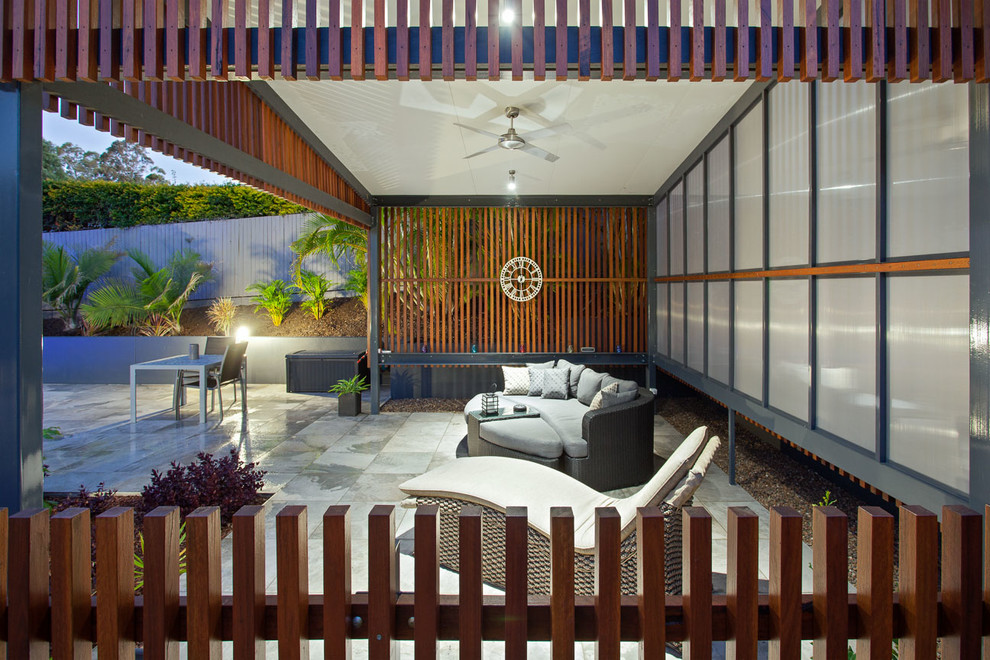 На фото: двор среднего размера на заднем дворе в современном стиле с покрытием из плитки и навесом с