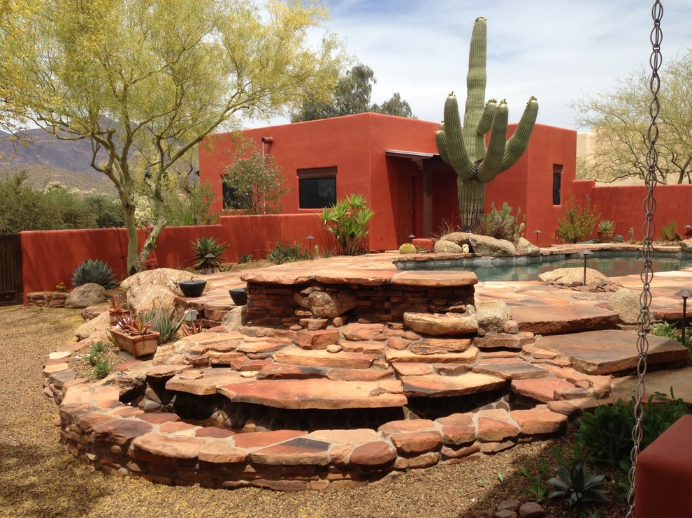 Ejemplo de patio de estilo americano grande sin cubierta en patio trasero con fuente y adoquines de piedra natural