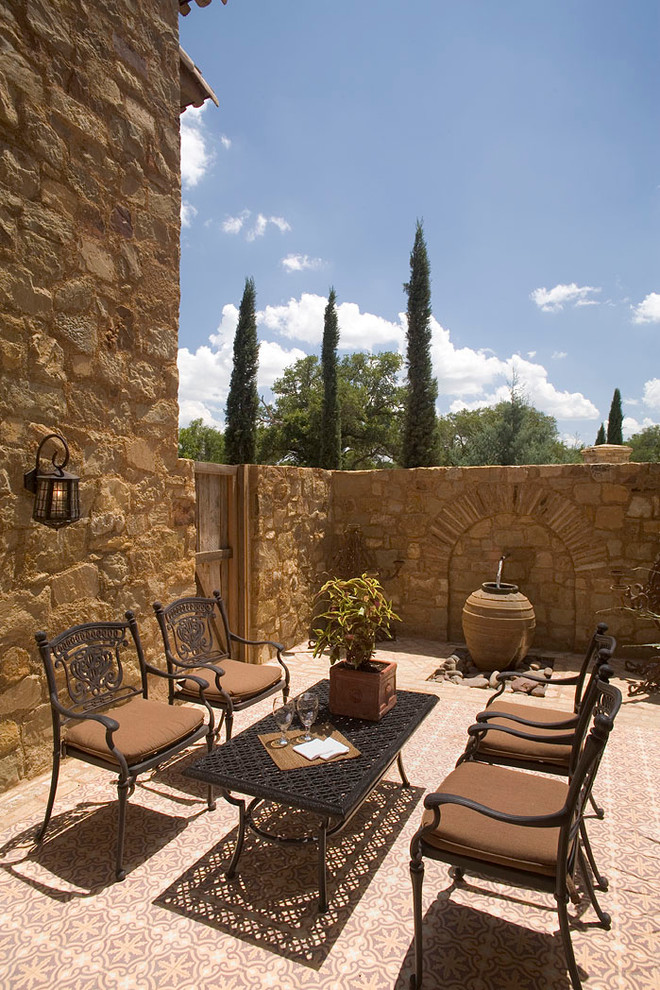 Photo of a mediterranean courtyard patio in Austin with a water feature.