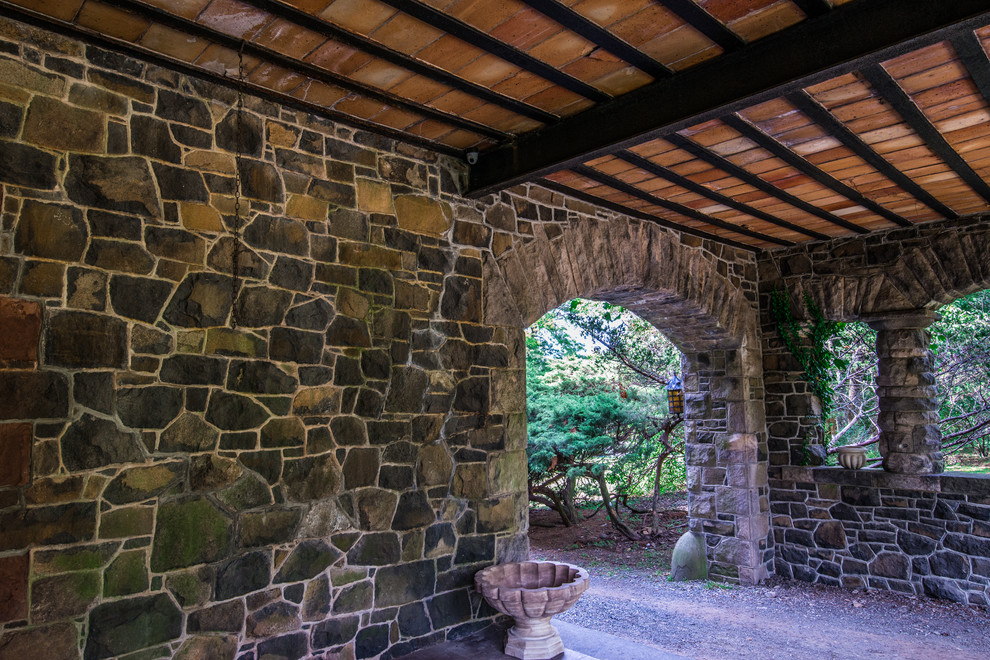 Foto de patio tradicional de tamaño medio en patio trasero y anexo de casas con adoquines de piedra natural