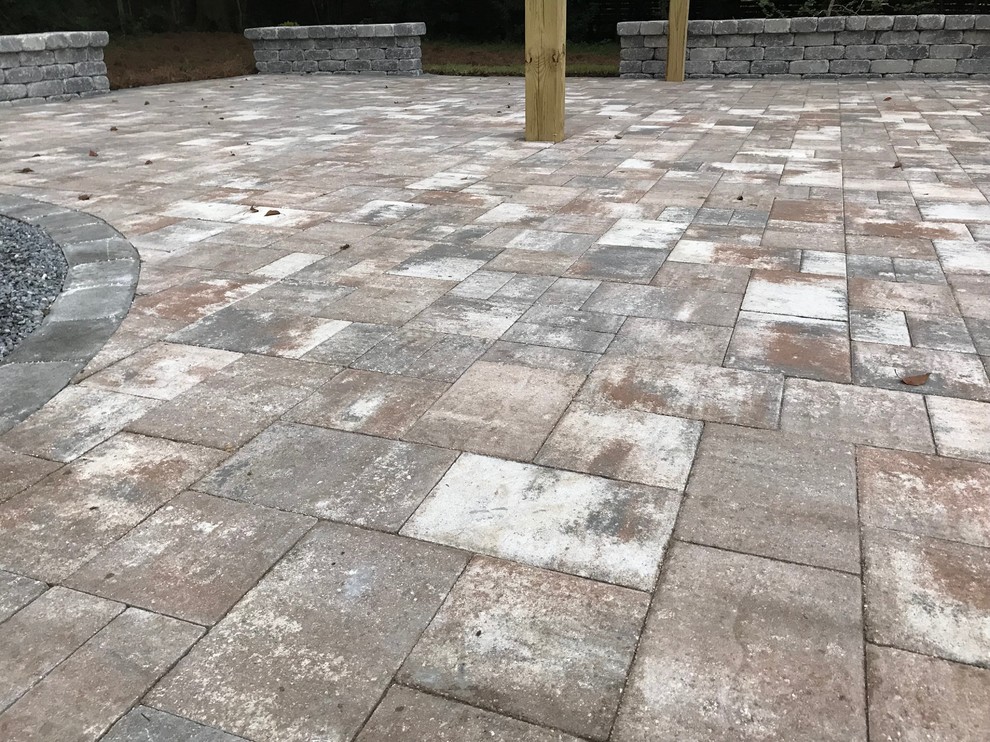 Minimalist backyard concrete paver patio photo in Other with a pergola