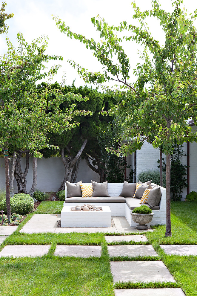Beach style backyard concrete paver patio photo in Orange County with a fire pit and no cover