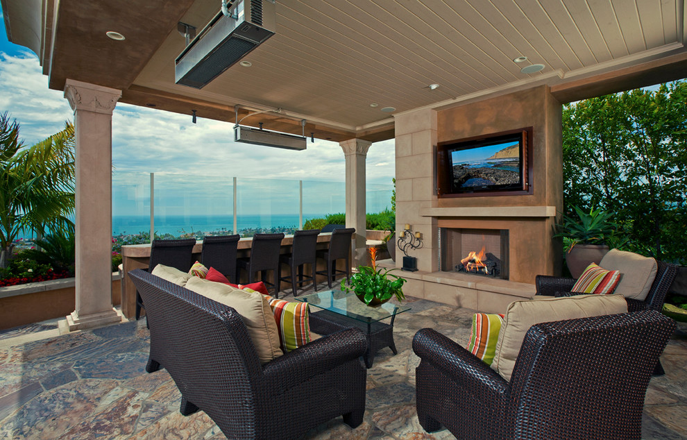 Überdachter, Mittelgroßer Moderner Patio hinter dem Haus mit Feuerstelle und Natursteinplatten in Orange County