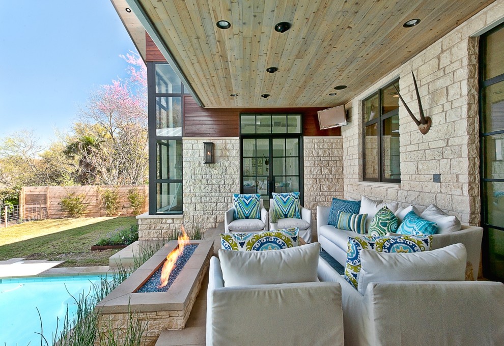 Cette photo montre une terrasse tendance avec un foyer extérieur.