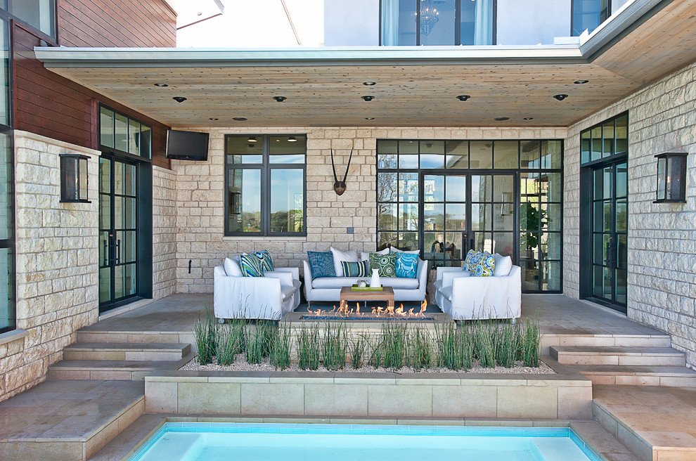 Inspiration for a contemporary patio remodel in Austin with a fire pit and a roof extension