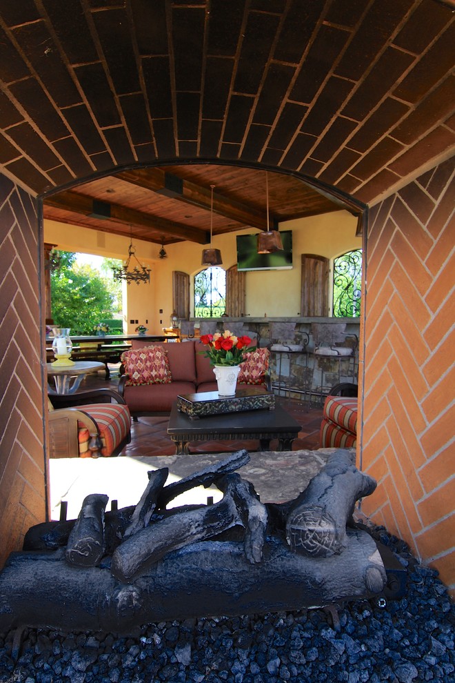 Immagine di un ampio patio o portico stile rurale nel cortile laterale con piastrelle e un gazebo o capanno