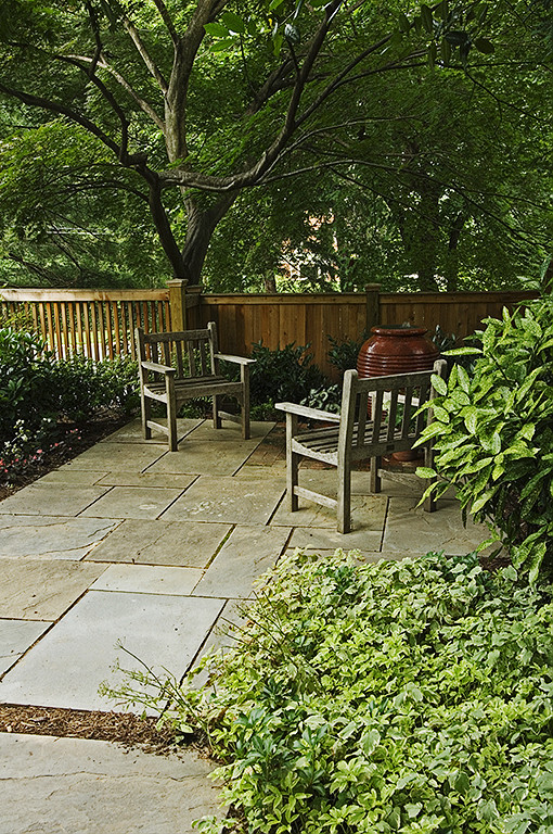Ejemplo de patio tradicional pequeño sin cubierta en patio trasero con fuente y adoquines de piedra natural
