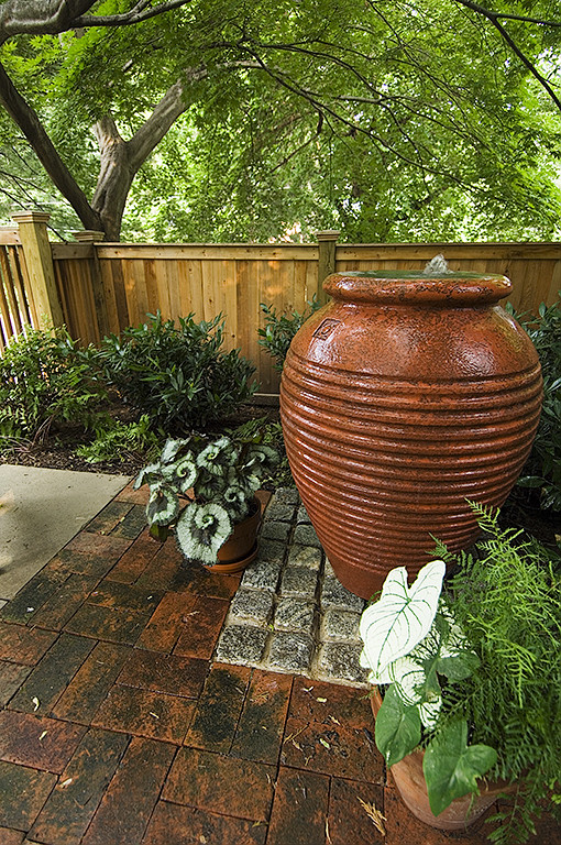 Foto de patio tradicional pequeño sin cubierta en patio trasero con fuente y adoquines de piedra natural