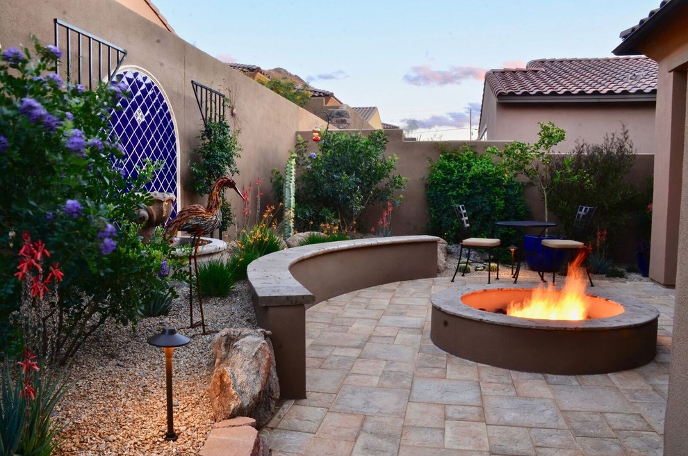 Réalisation d'une terrasse arrière sud-ouest américain de taille moyenne avec un foyer extérieur, du carrelage et aucune couverture.