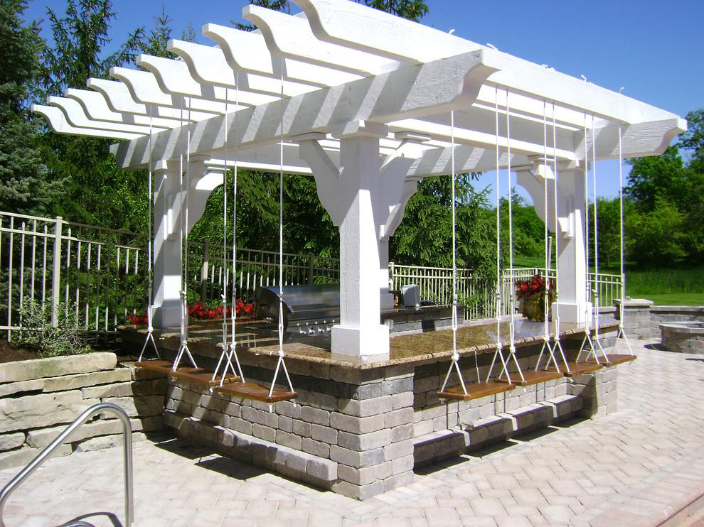 Eclectic patio in Milwaukee with an outdoor kitchen and a pergola.