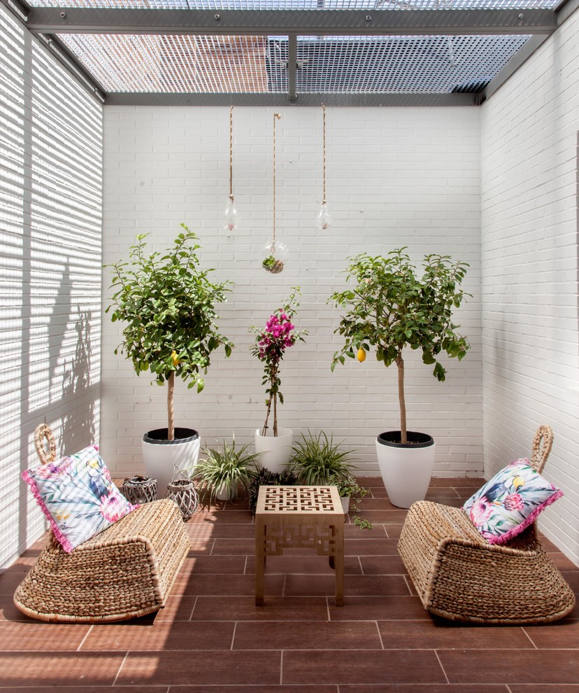 Immagine di un piccolo patio o portico mediterraneo in cortile con un giardino in vaso