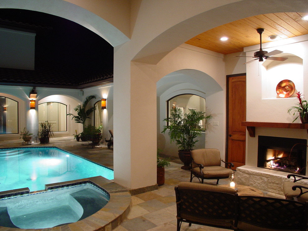 Inspiration for a mid-sized mediterranean courtyard tile patio remodel in Austin with a fire pit and a roof extension