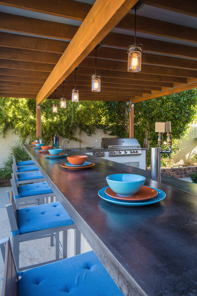 Cette photo montre une grande terrasse arrière tendance avec une cuisine d'été, du carrelage et un auvent.