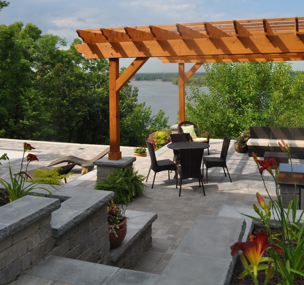 Medium sized contemporary back patio in Chicago with an outdoor kitchen, brick paving and a pergola.