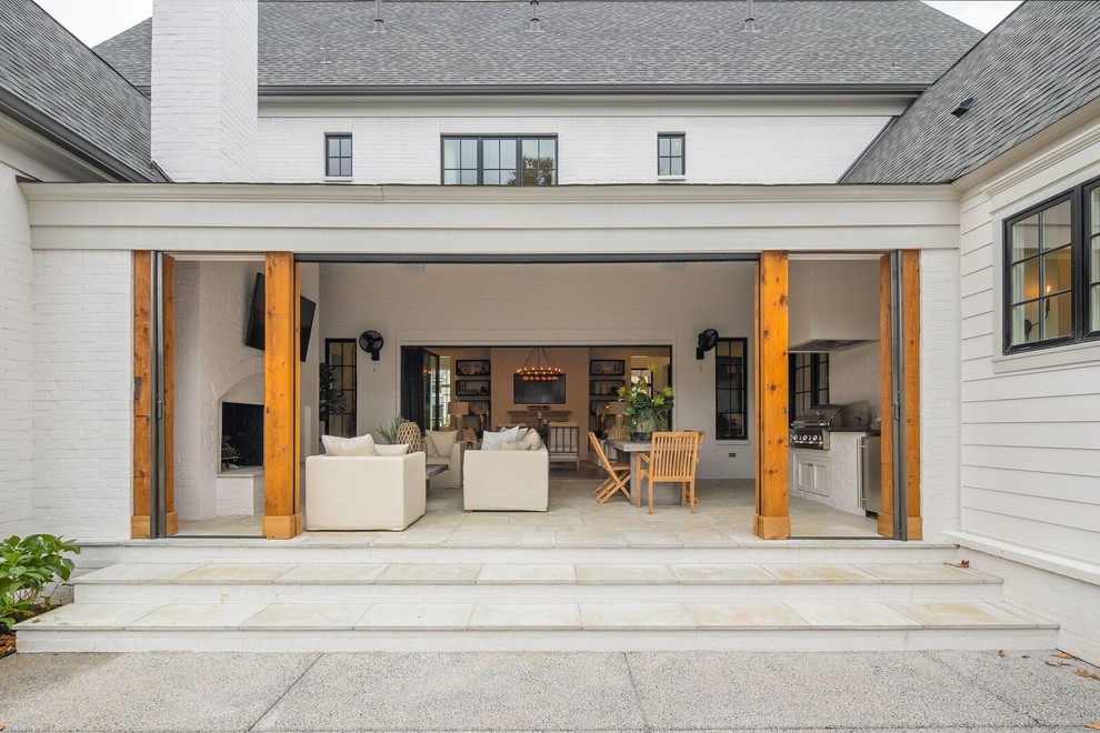 Стильный дизайн: большой двор на заднем дворе в стиле неоклассика (современная классика) с летней кухней, покрытием из плитки и навесом - последний тренд