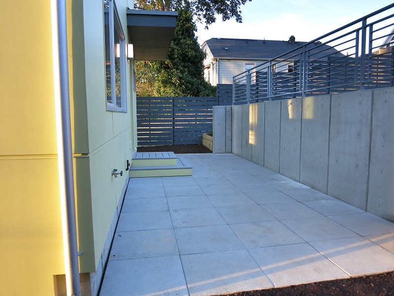 Inspiration för en mellanstor funkis uteplats på baksidan av huset, med marksten i betong