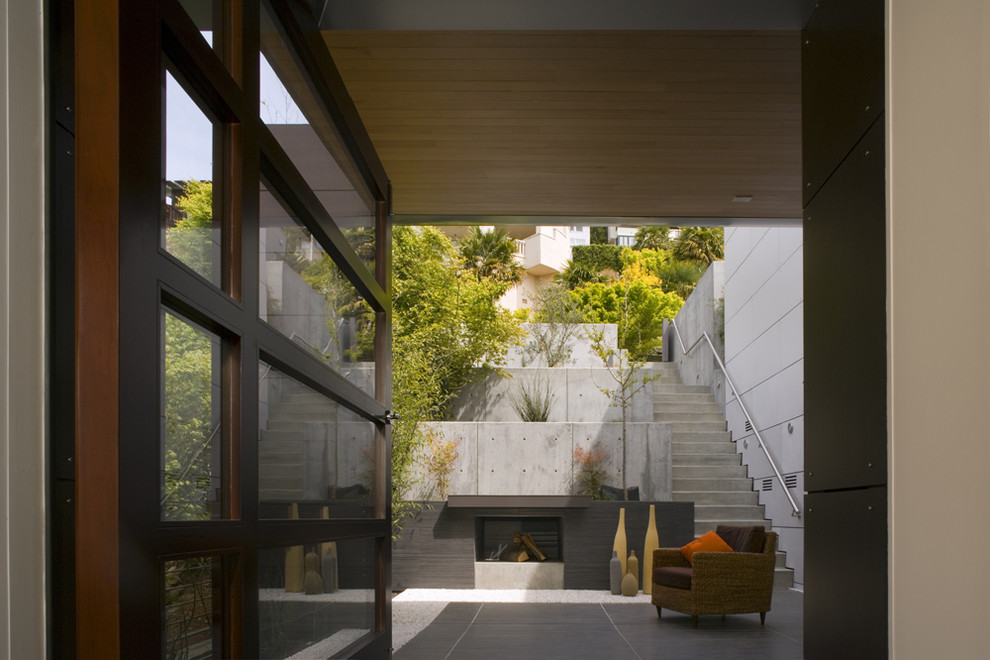 Exemple d'une terrasse tendance avec une cour et un foyer extérieur.