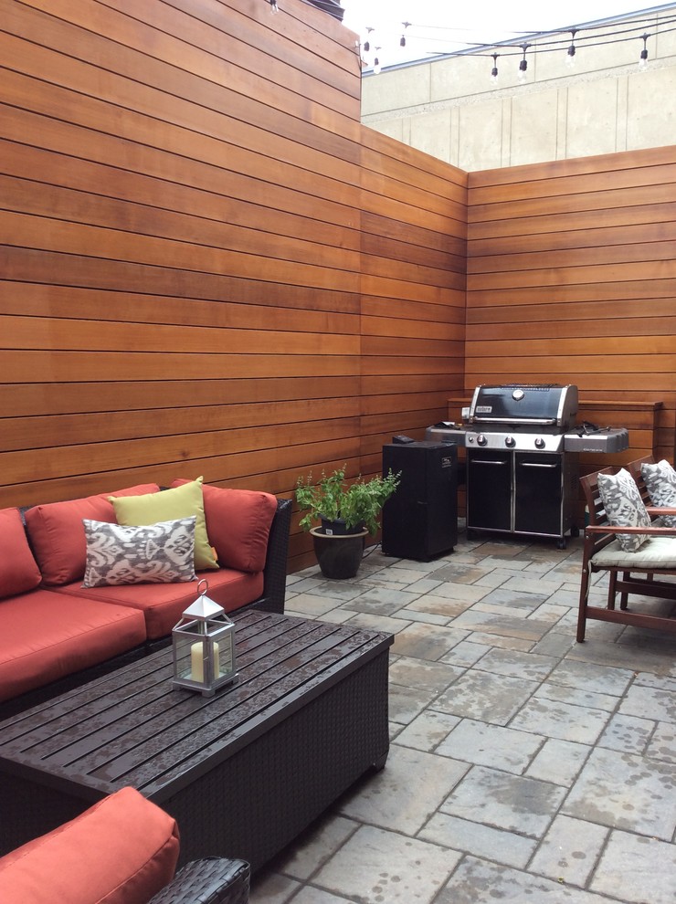 This is an example of a small modern patio in Boston with concrete paving and no cover.