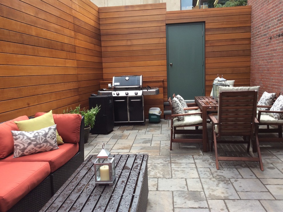 This is an example of a small modern patio in Boston with concrete paving and no cover.