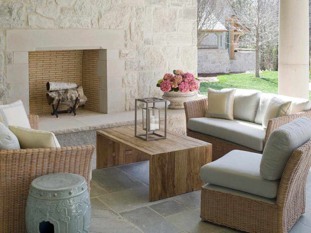 Ejemplo de patio clásico con adoquines de piedra natural y chimenea