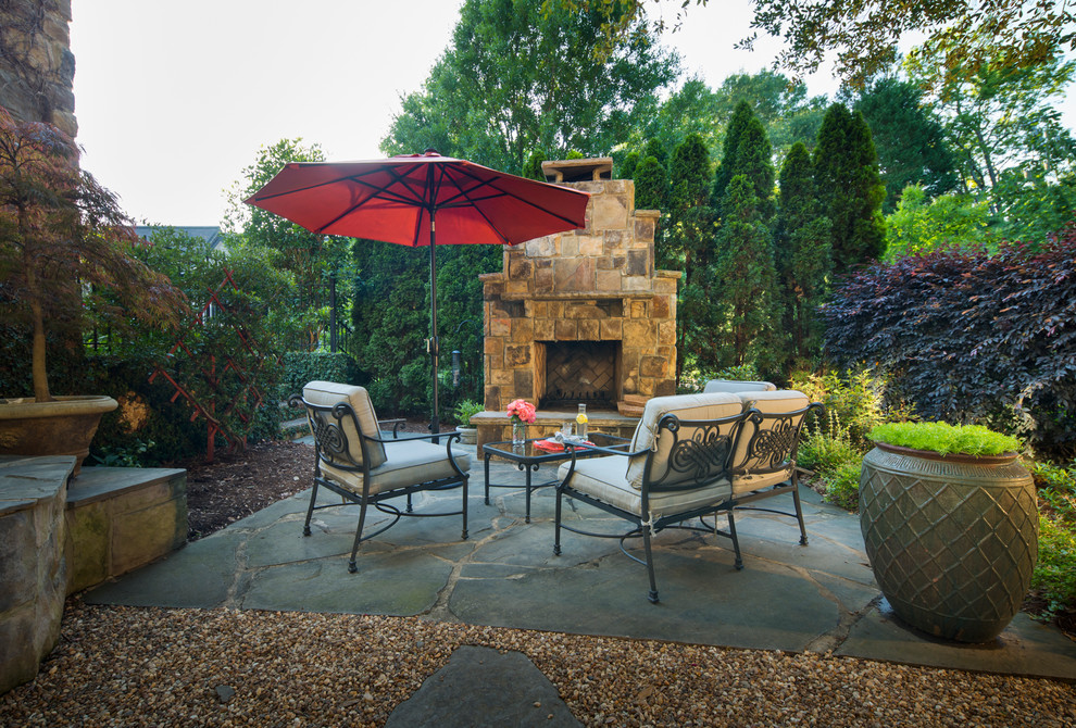 Ejemplo de patio rústico de tamaño medio sin cubierta en patio trasero con brasero y adoquines de piedra natural