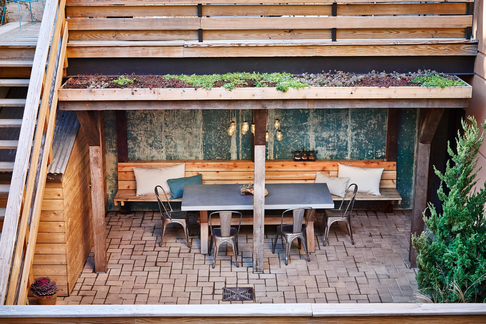 На фото: двор среднего размера на заднем дворе в стиле рустика с мощением клинкерной брусчаткой, летней кухней и навесом