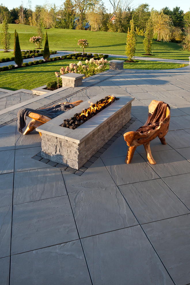 Diseño de patio clásico sin cubierta en patio trasero con brasero y adoquines de piedra natural