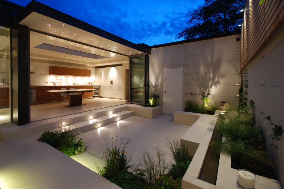 Réalisation d'une terrasse design avec une cour, une dalle de béton et aucune couverture.