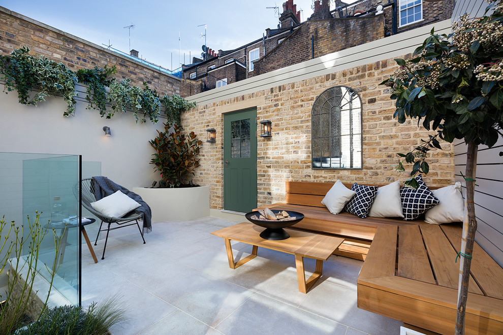 Foto di un piccolo patio o portico tradizionale dietro casa con un focolare, pavimentazioni in cemento e nessuna copertura