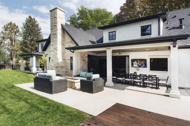 Esempio di un ampio patio o portico tradizionale dietro casa con un focolare, cemento stampato e un tetto a sbalzo