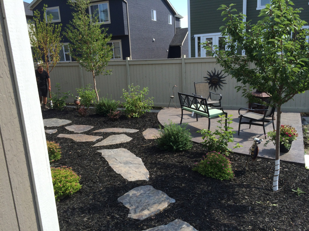 This is an example of a small back patio in Calgary with a fire feature and concrete slabs.