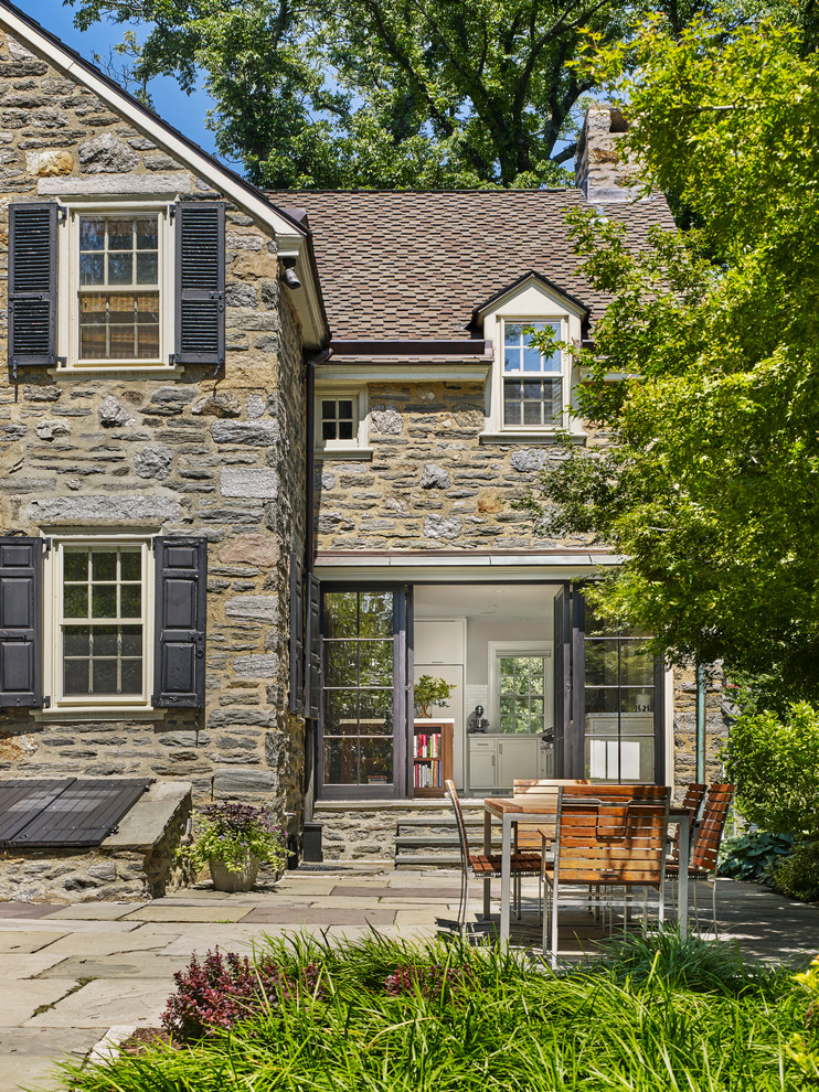 Immagine di un grande patio o portico chic dietro casa con pavimentazioni in pietra naturale