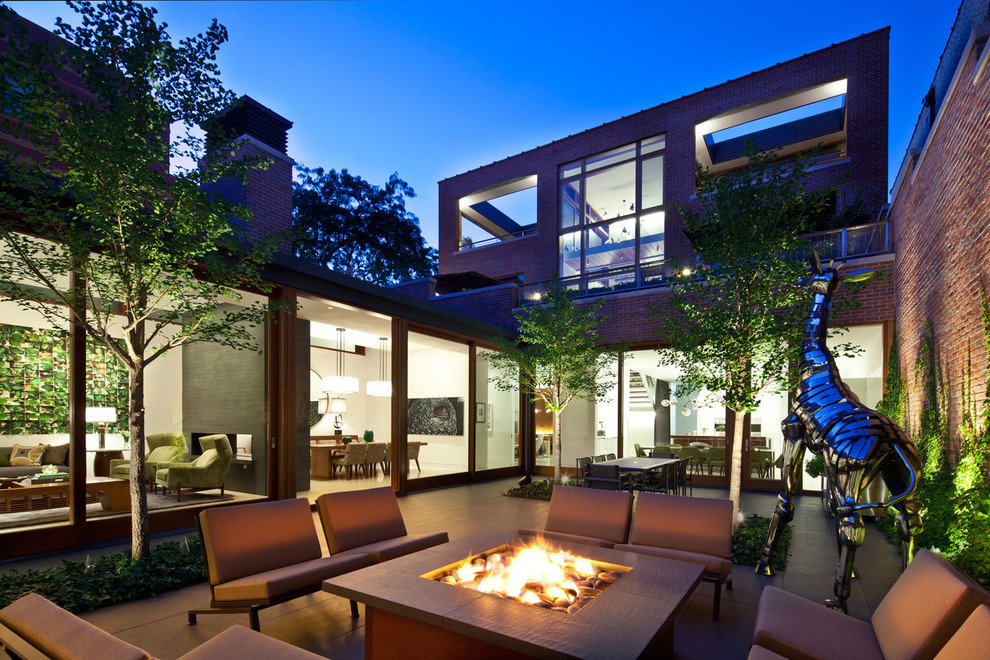 Aménagement d'une terrasse contemporaine avec une cour et un foyer extérieur.
