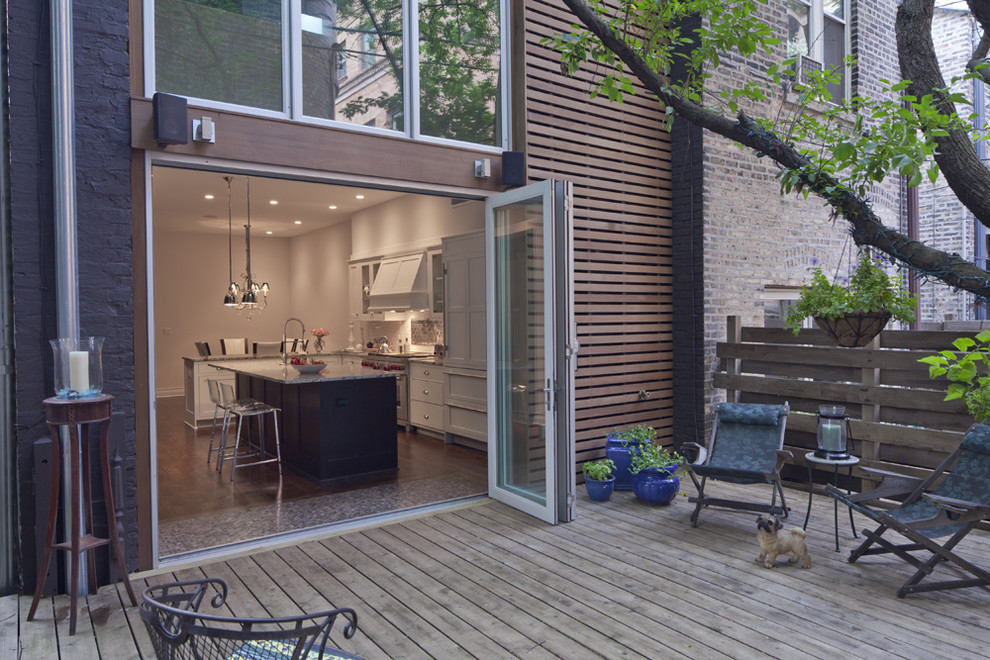 Large modern back patio in Chicago with decking and no cover.