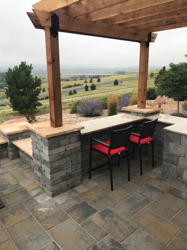 Patio kitchen - concrete paver patio kitchen idea in Denver with a pergola