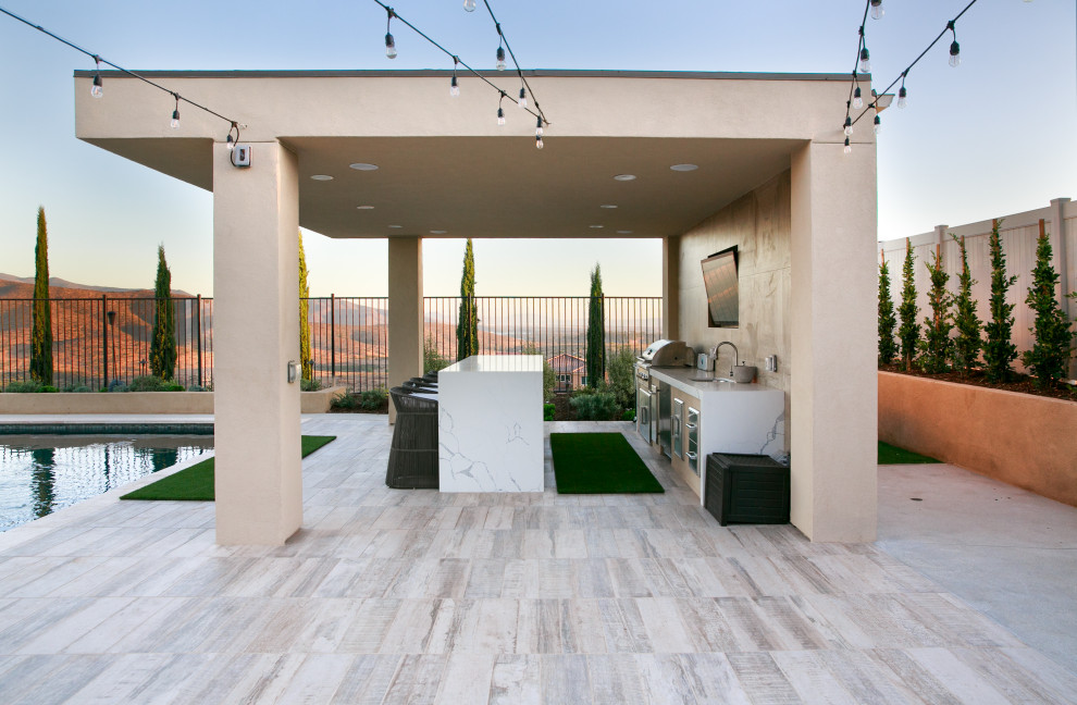 Exemple d'une grande terrasse arrière tendance avec une cuisine d'été, du carrelage et un gazebo ou pavillon.