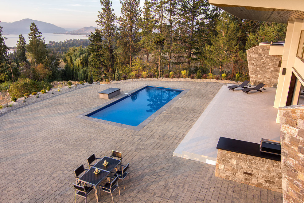 Réalisation d'une très grande terrasse design avec des pavés en béton.