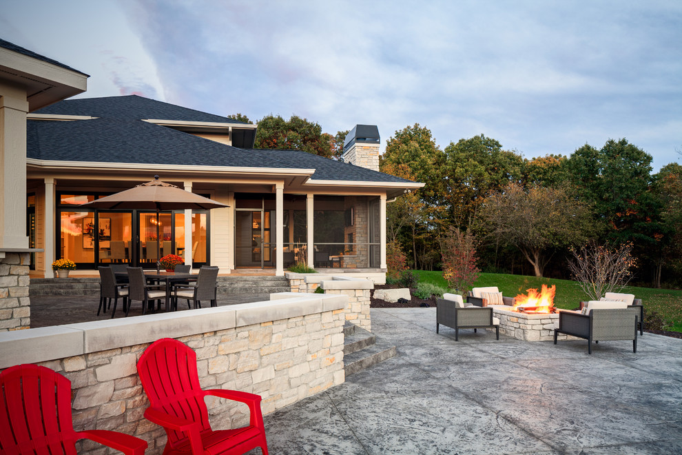 Modelo de patio clásico renovado grande en patio trasero con cocina exterior, suelo de hormigón estampado y cenador