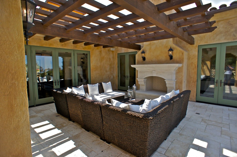 Example of a large tuscan side yard stone patio design in Santa Barbara with a fire pit and an awning