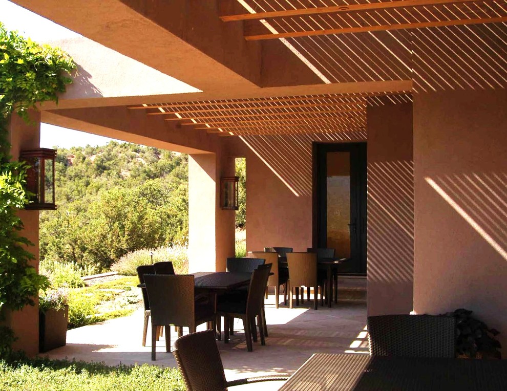 Idee per un patio o portico american style di medie dimensioni e dietro casa con pavimentazioni in pietra naturale e una pergola