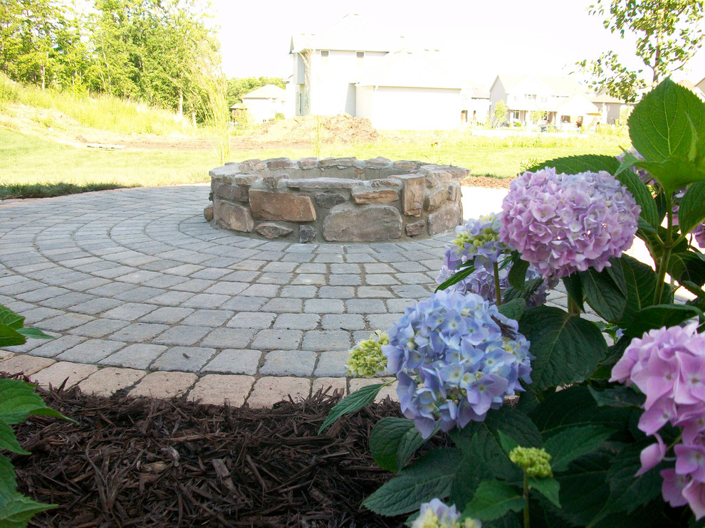 Circle patio with a stone veneered fire pit Traditional Patio